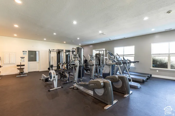 Fitness center featuring recessed lighting, a variety of exercise equipment, and multiple windows