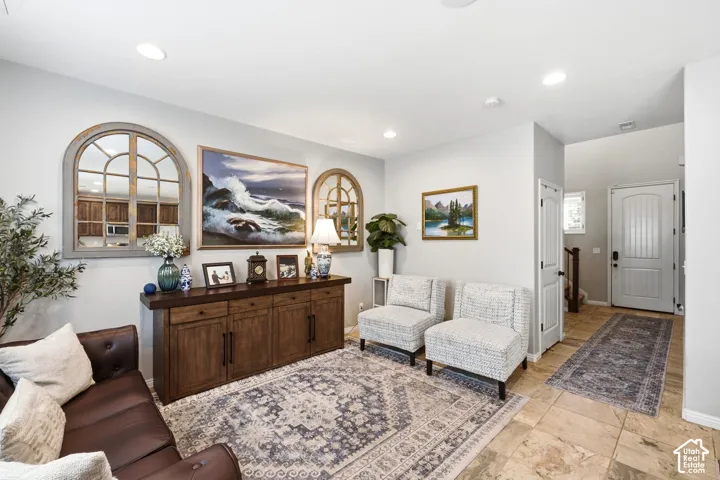 Recessed lighting illuminates the living space with tile flooring