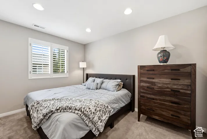 Recessed lighting, window with white plantation shutters, and light gray wall paint