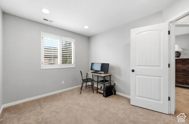 Recessed lighting with white trim, white window shutters, white baseboards, and a white interior door with dark hardware