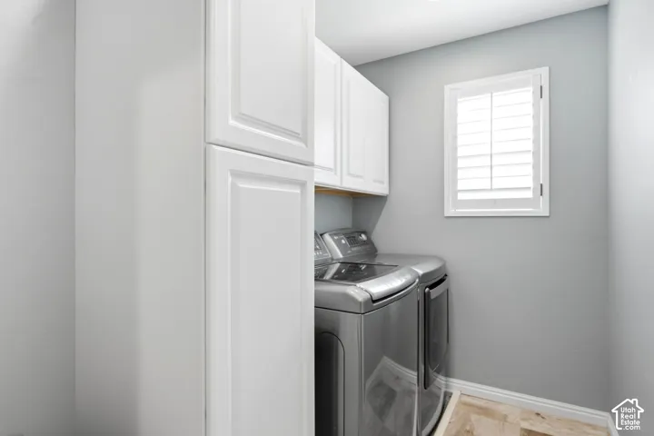 White shaker-style cabinetry, recessed ceiling lighting, light wood-finish flooring, and a window with plantation shutters