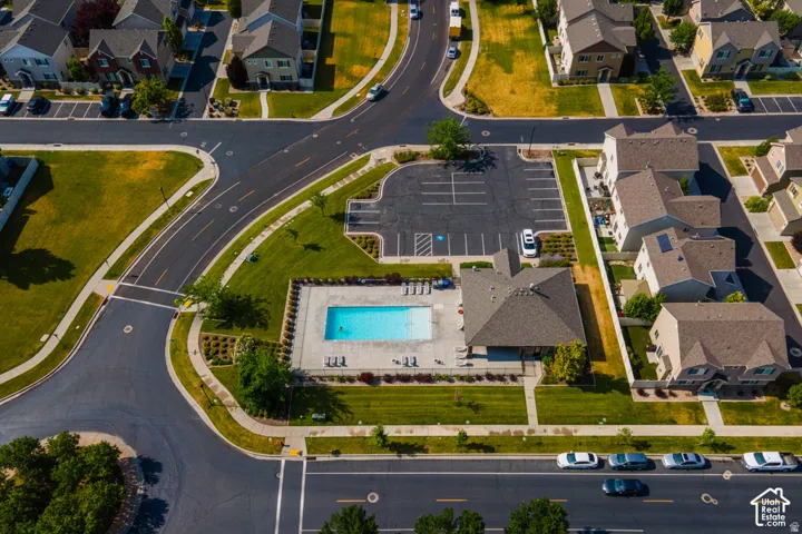 Community offering a swimming pool, clubhouse, paved parking area, and residential streets with sidewalks