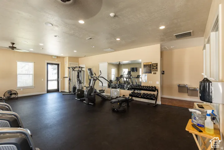 Fitness center with resilient rubber flooring, recessed lighting, and a mirrored wall