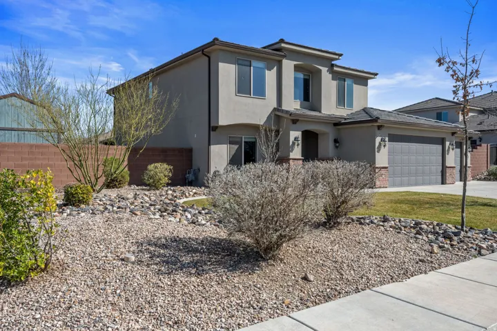 Stucco exterior with brick accents, attached garage, and a concrete driveway