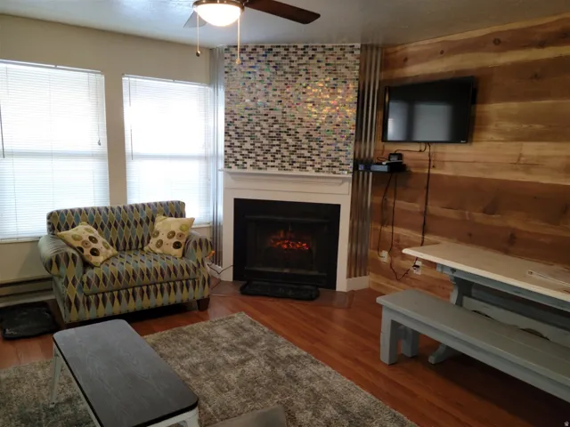 Corner fireplace with a mosaic tile surround and white mantel