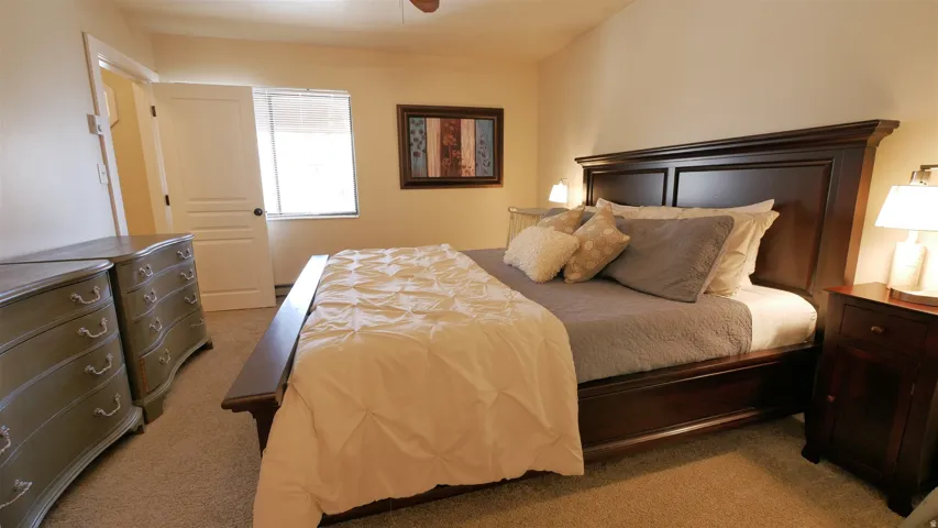 Recessed window with blinds, light-colored wall paint, and ceiling fan