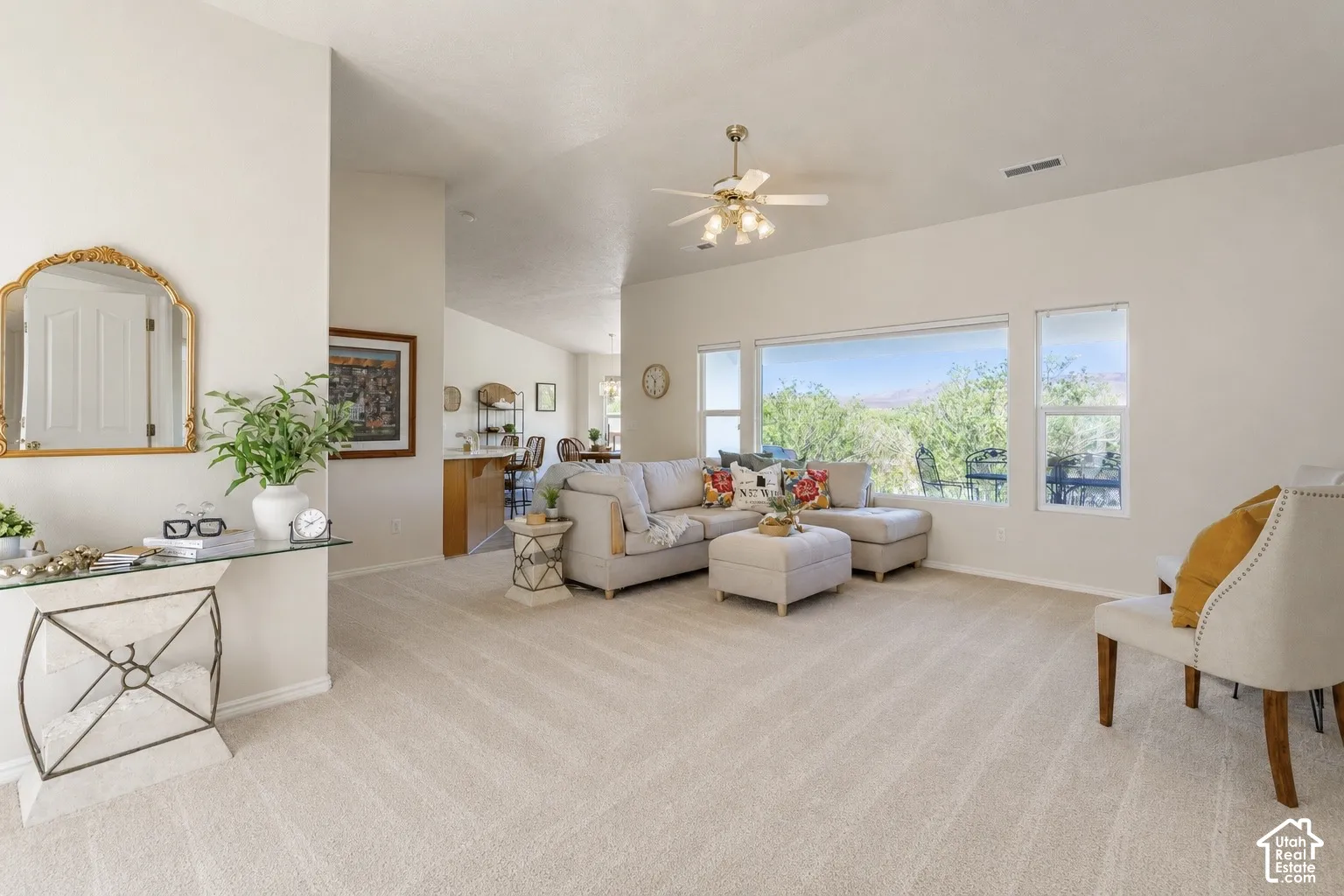 Spacious living area with vaulted ceilings, recessed lighting, and expansive windows