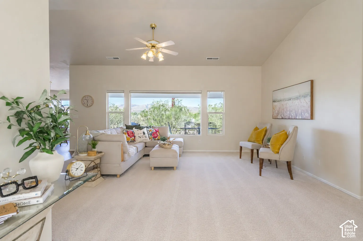 Vaulted ceilings, a multi-window wall, and a ceiling fan with integrated lighting