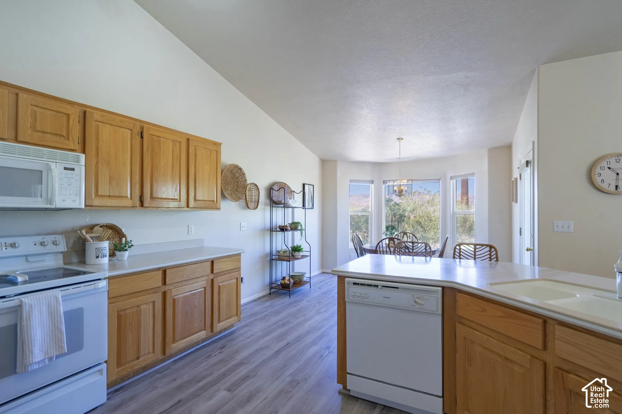 Kitchen featuring wood-finish cabinetry, light-toned countertops, and wood-finish flooring