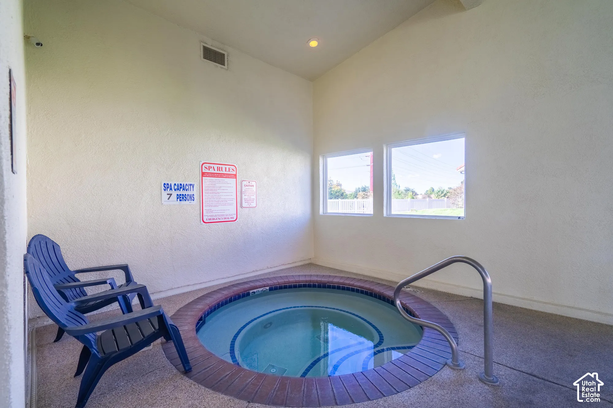 Indoor spa with a tiled surround, integrated handrail, and recessed lighting
