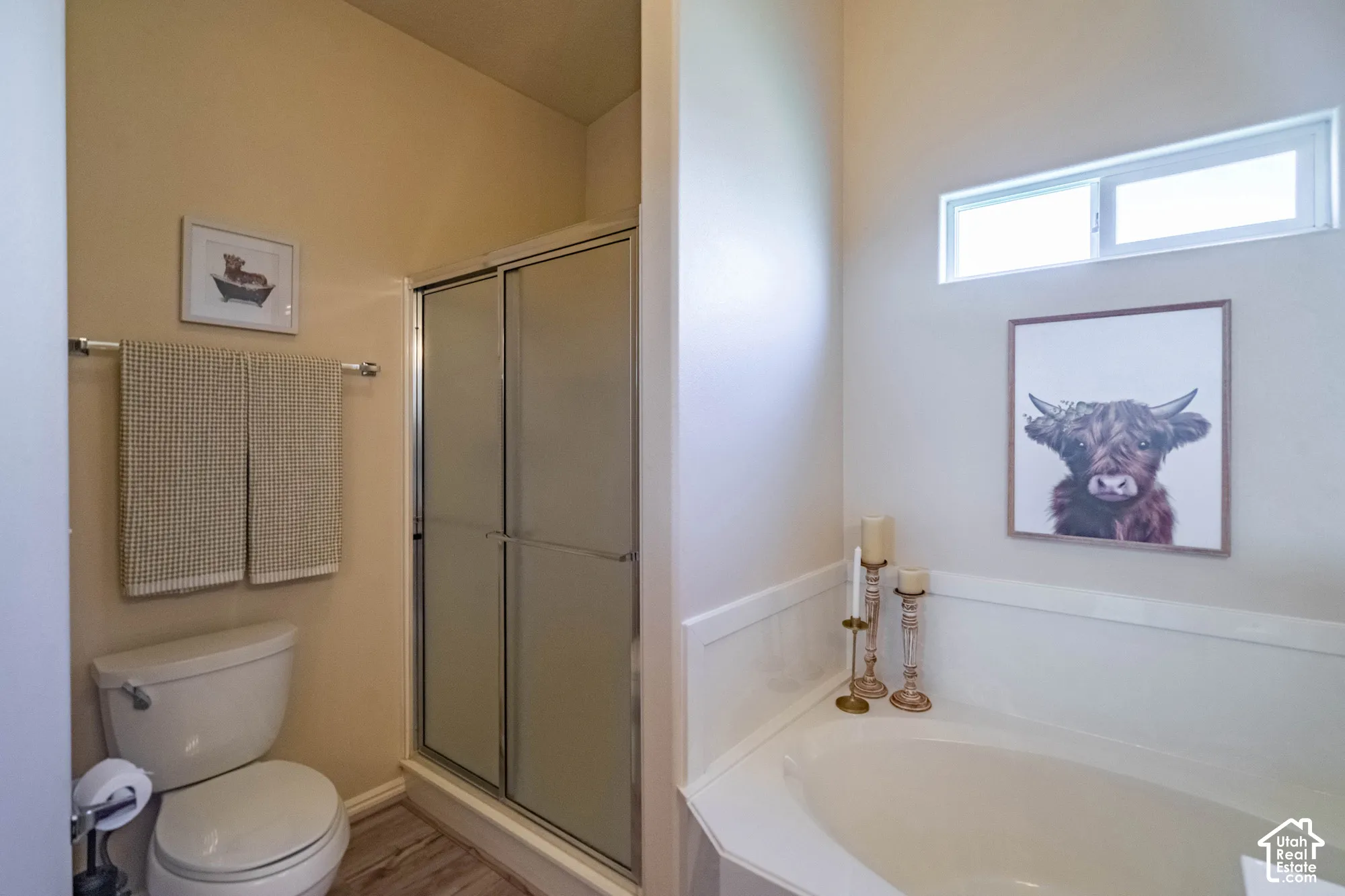 Built-in corner bathtub, glass-enclosed shower, and a high transom window