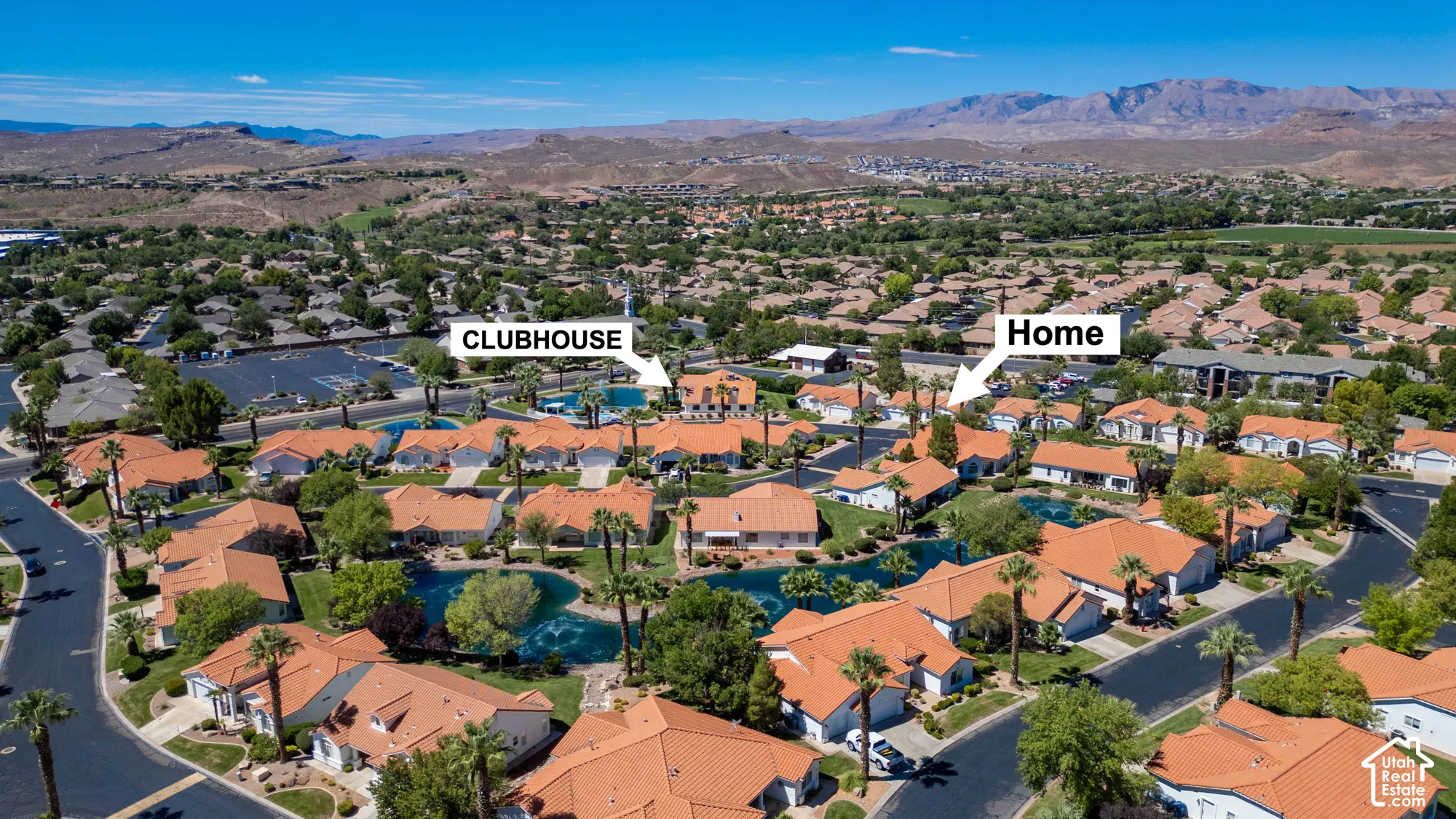 Community landscape featuring mature palm trees and residential properties with red tile roofs