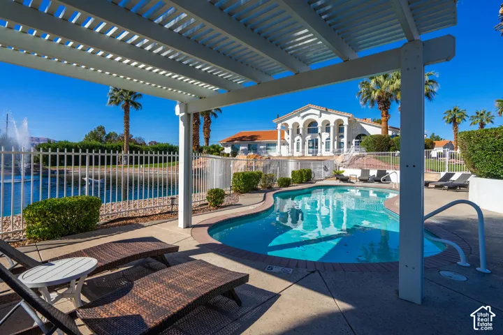 Resort-style pool with integrated steps, surrounded by a paved patio