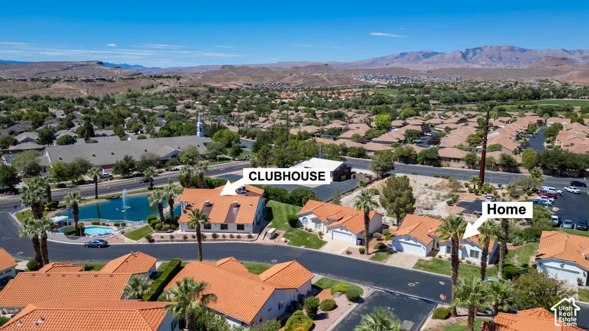 Aerial view showcasing this residence within a gated community featuring resort-style amenities including a sparkling pool, spa, and clubhouse