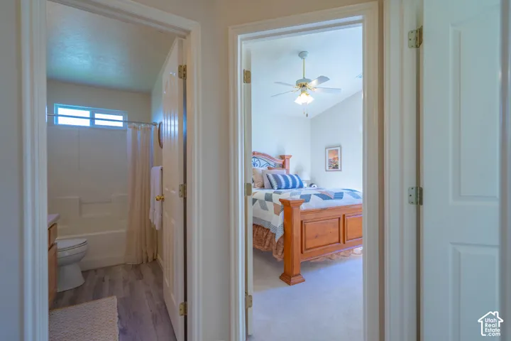 Bedroom featuring vaulted ceiling, ceiling fan with light fixture, and carpet flooring