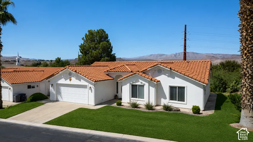 Mediterranean-style exterior with a stucco finish and terracotta tile roofPhoto of lawn is altered to be more green.
