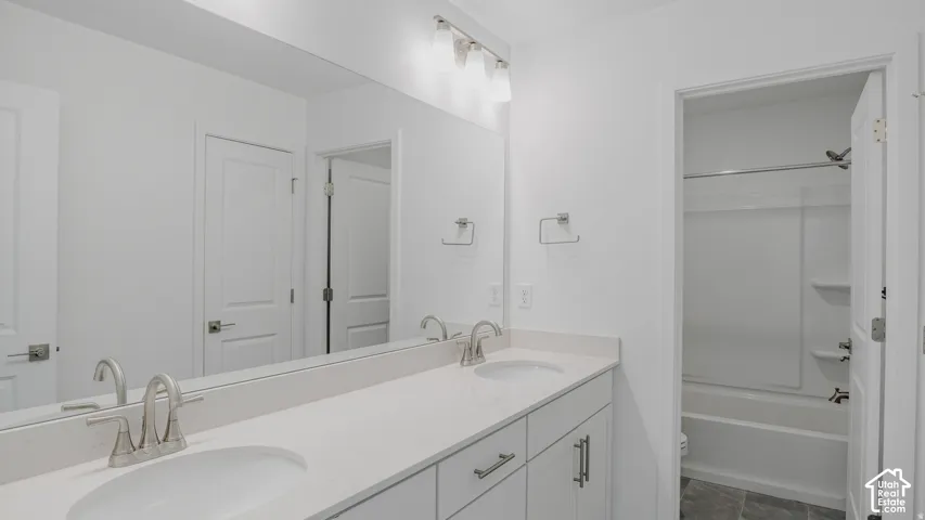 Dual undermount sinks with brushed nickel faucets, a spacious vanity mirror, and white cabinetry with brushed nickel hardware