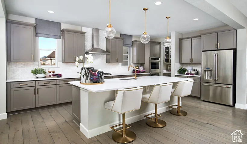 Kitchen featuring wood-finish flooring, gray cabinetry, white countertops, and stainless steel appliances