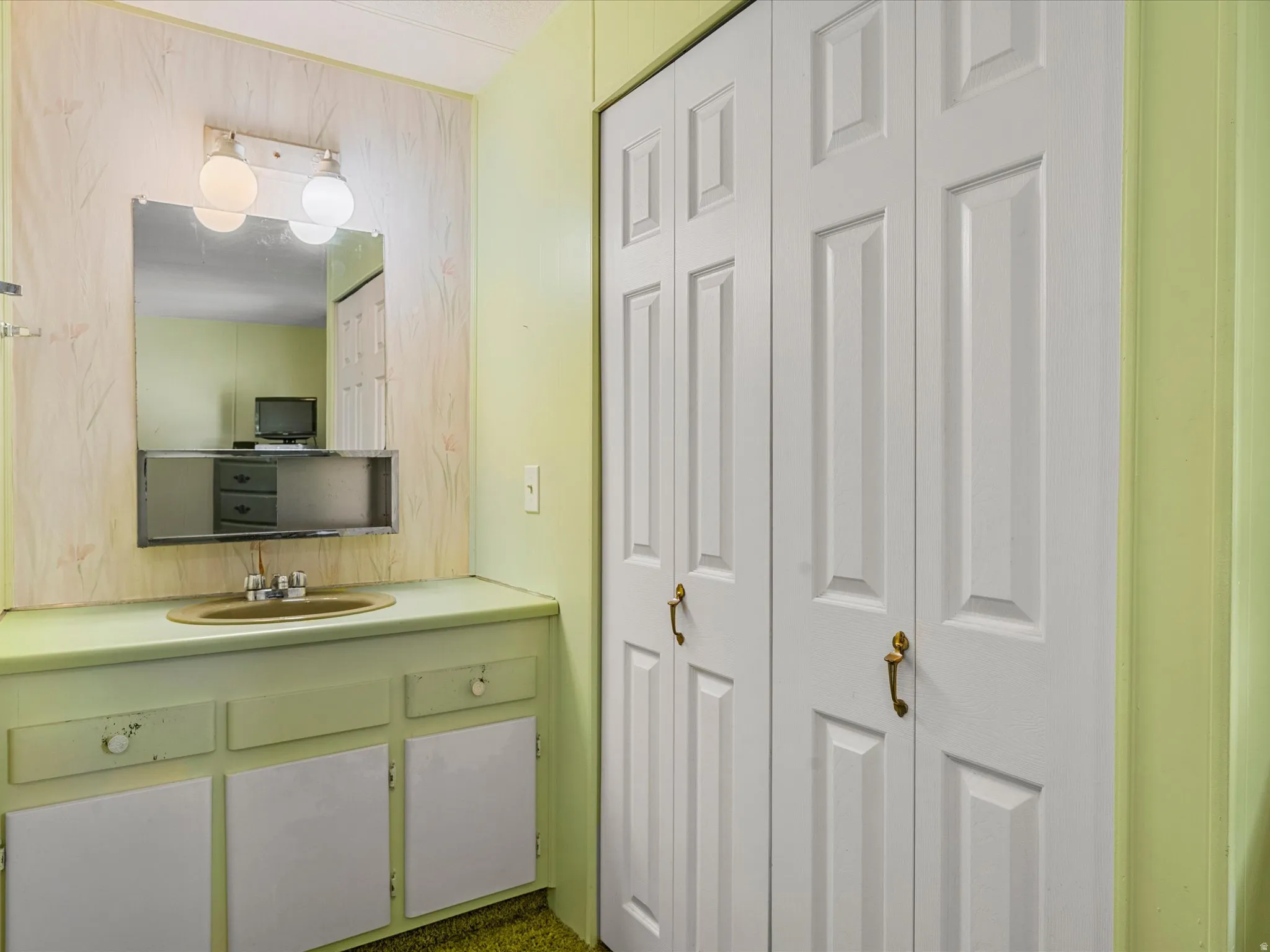 Full vanity with integrated sink, wall-mounted mirror, and overhead lighting