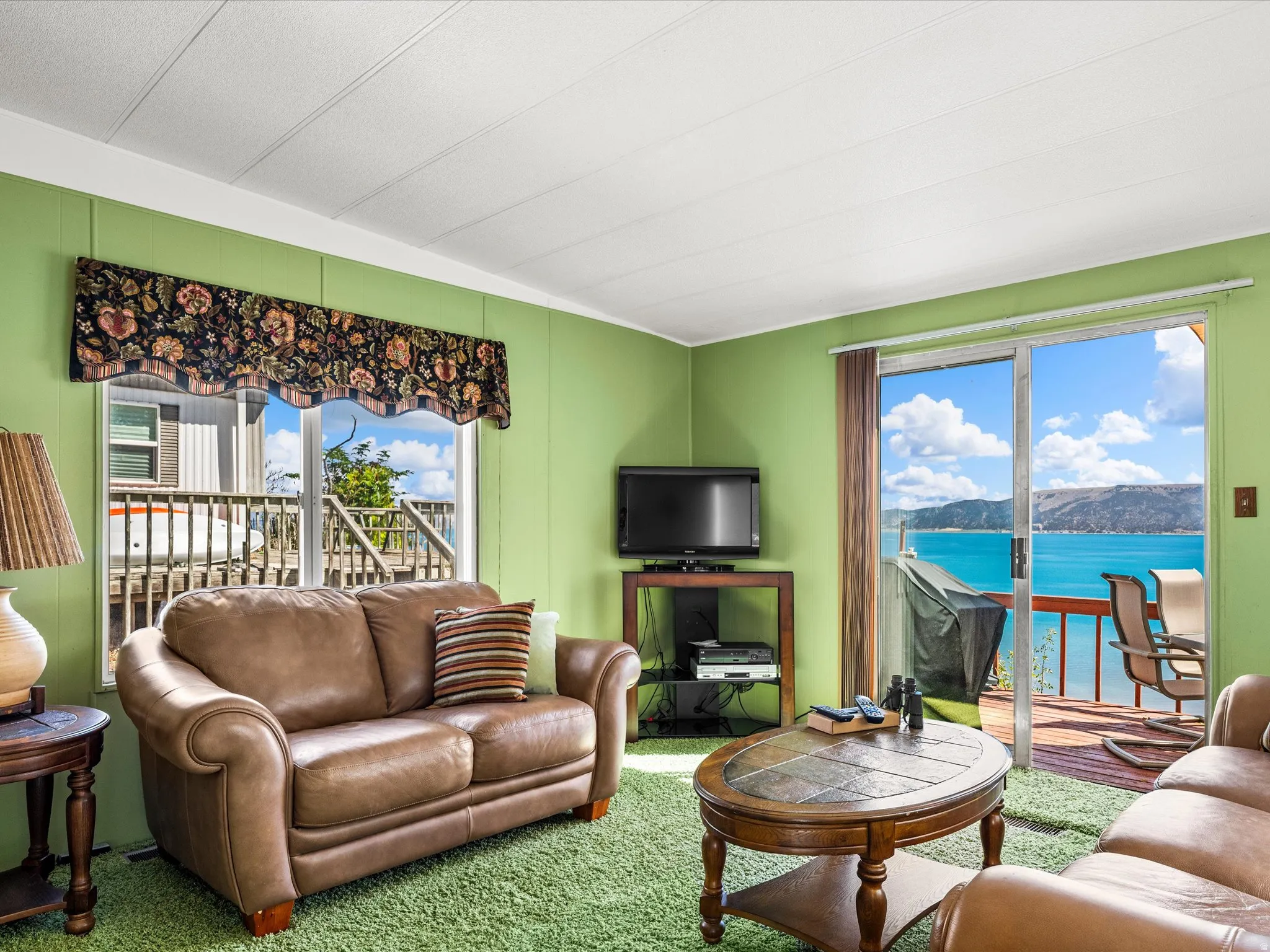 Living area with light green walls and a white paneled ceiling