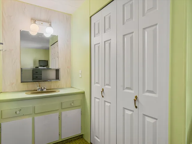 Full vanity with integrated sink, wall-mounted mirror, and overhead lighting