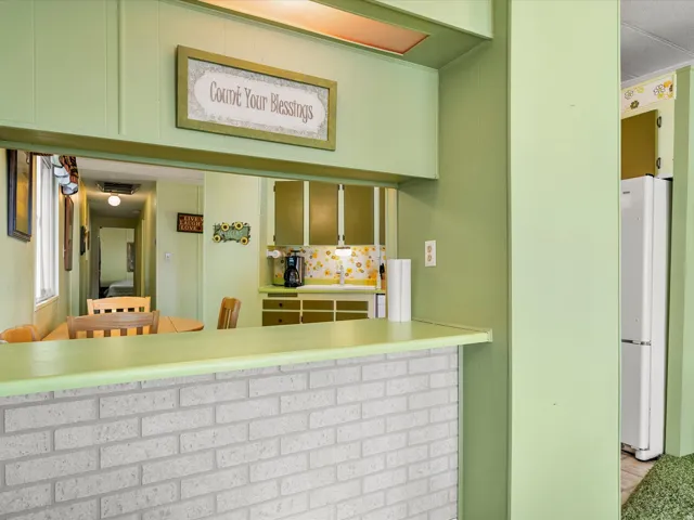 Pass-through window, light brick-finish breakfast bar, built-in cabinetry, and integrated paneling