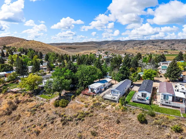 Terraced property with multiple residences, established landscaping, and a distant mountainous backdrop