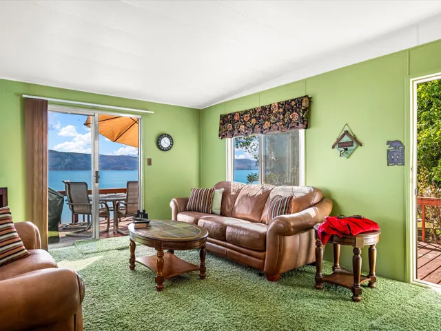 Sliding glass door opening to an outdoor deck, a window with water and mountain scenery, and a second exterior door