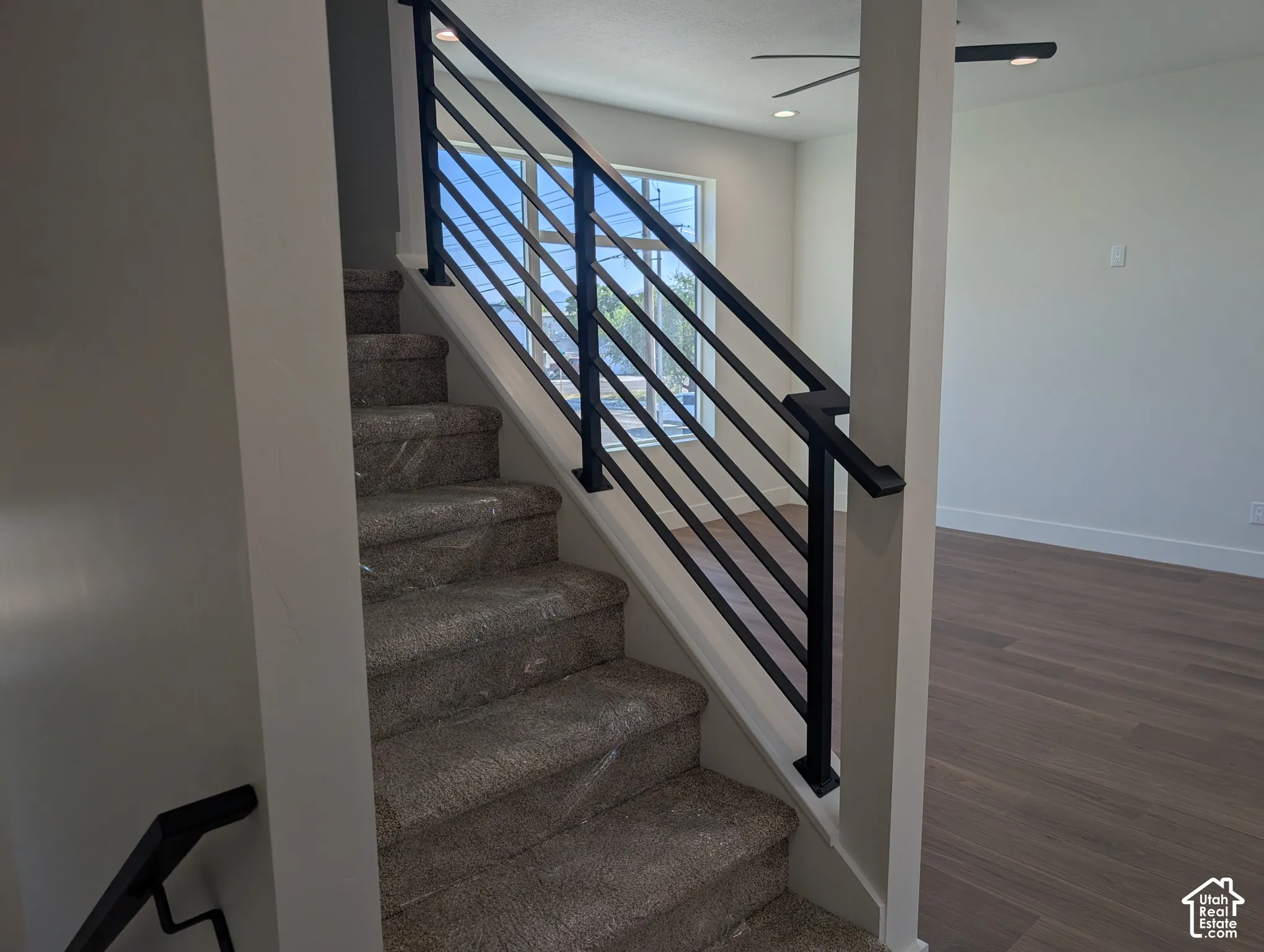 Staircase with contemporary black metal railing and carpeted treads