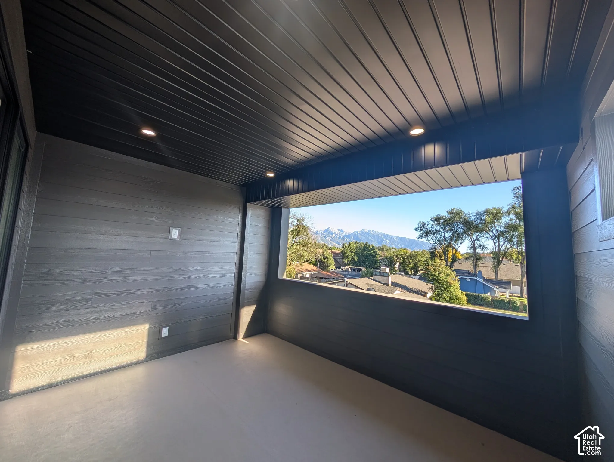 Covered outdoor space featuring a slatted ceiling, recessed lighting, and a panoramic mountain backdrop