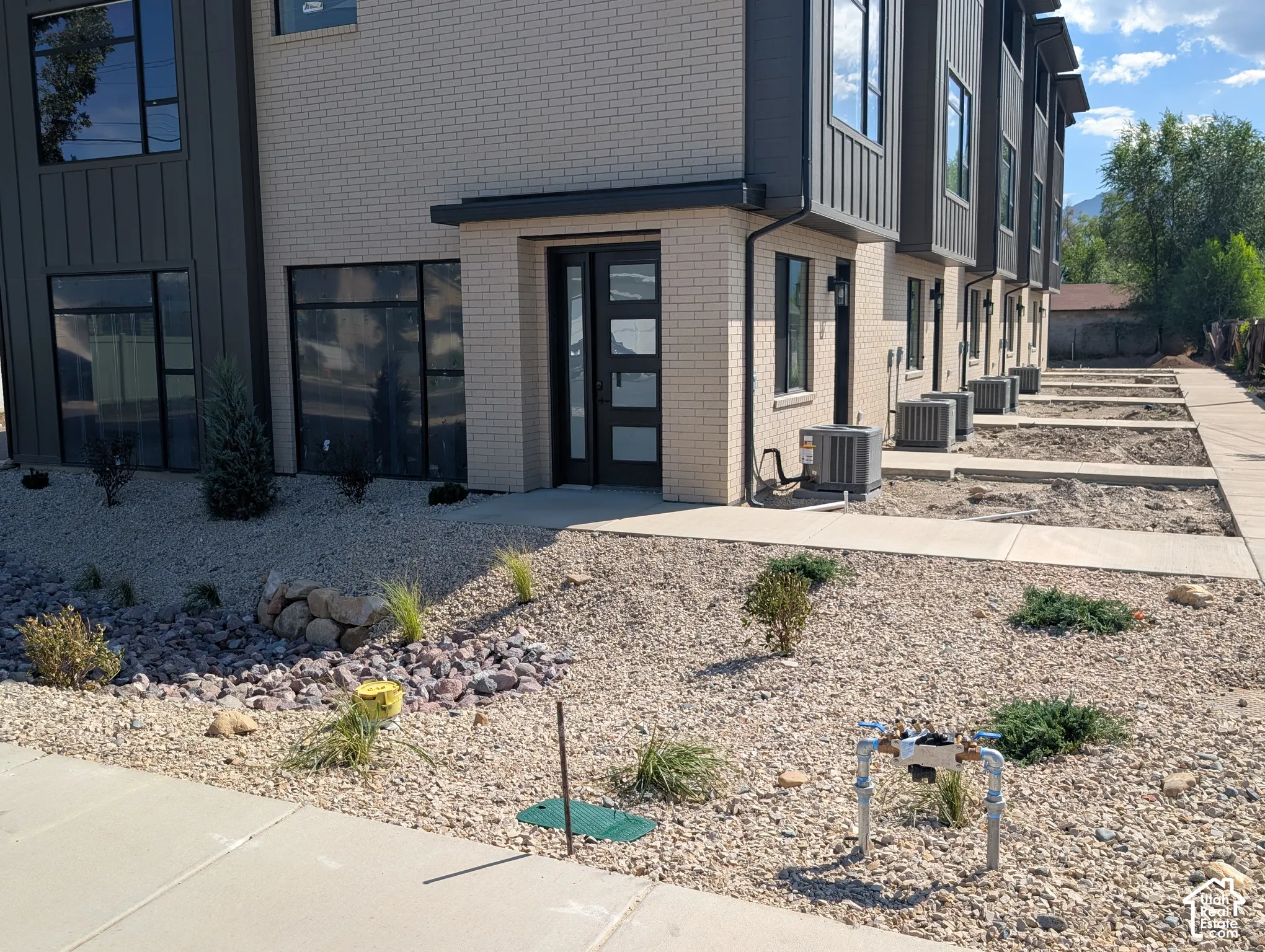 Modern exterior featuring light brick and vertical panel siding