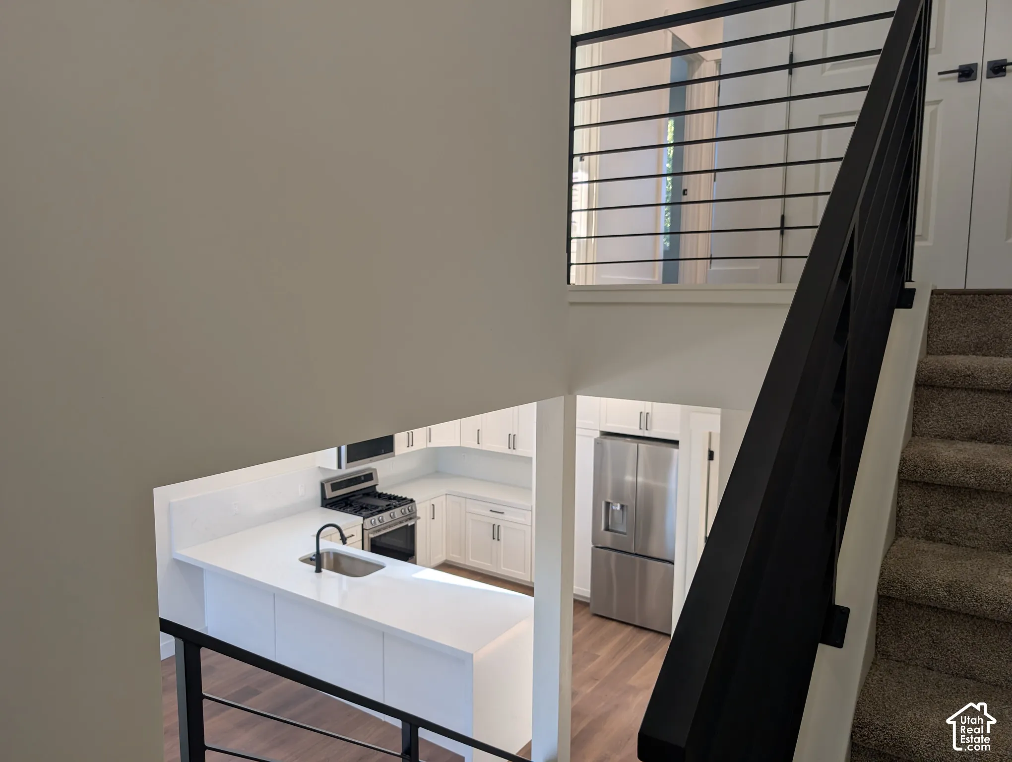Modern kitchen featuring white cabinetry, a stainless steel gas range, and a stainless steel French door refrigerator