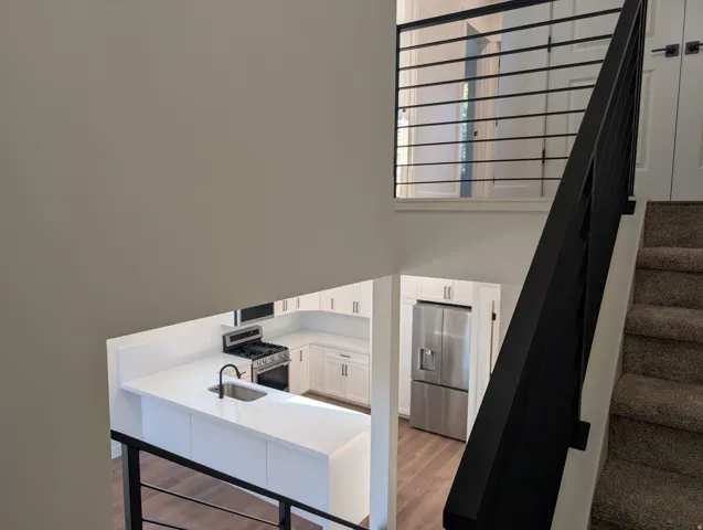 Modern kitchen featuring white cabinetry, a stainless steel gas range, and a stainless steel French door refrigerator