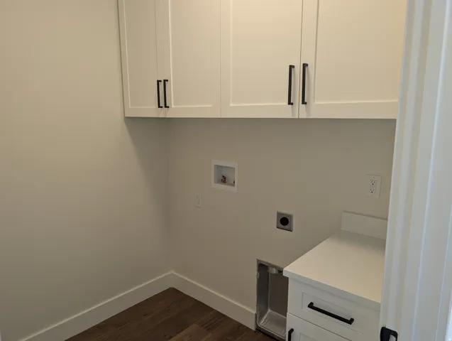 White shaker-style cabinetry with black hardware, wood-finish flooring, and a white countertop