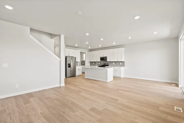 Open-concept design featuring wood-finish flooring, recessed lighting, and a modern kitchen