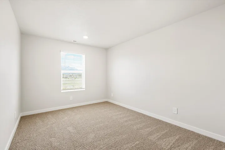 Recessed lighting, neutral wall paint, window with blinds, and carpeting