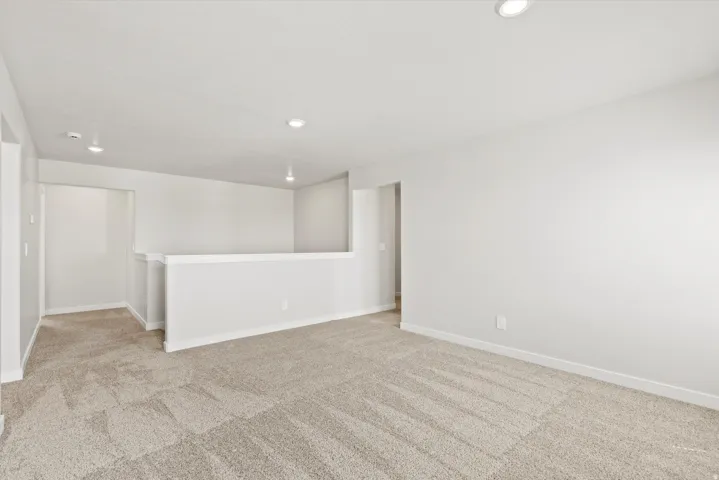 Carpeted floor, recessed ceiling lights, and painted walls