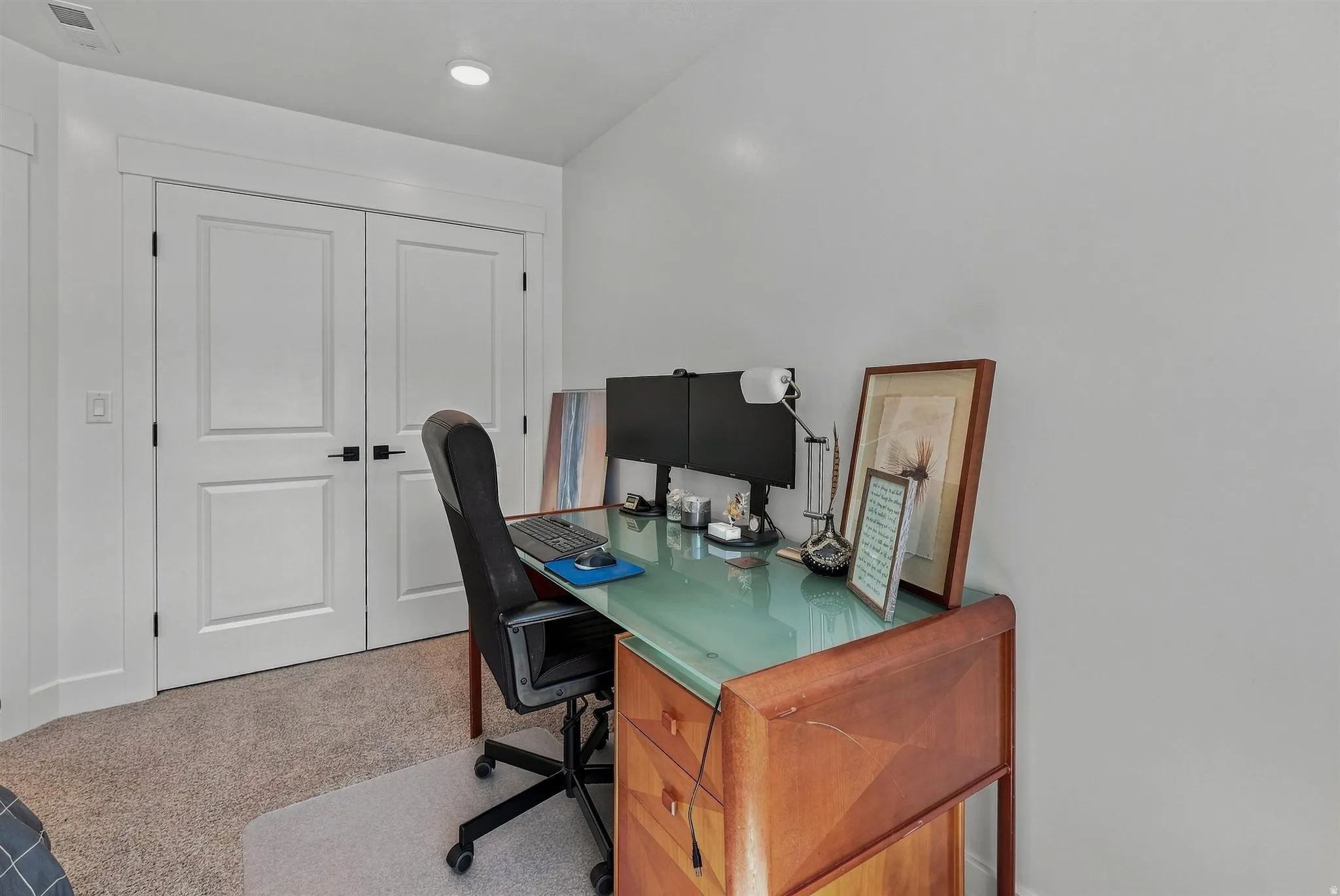 Double panel doors, recessed lighting, and light-toned carpeting
