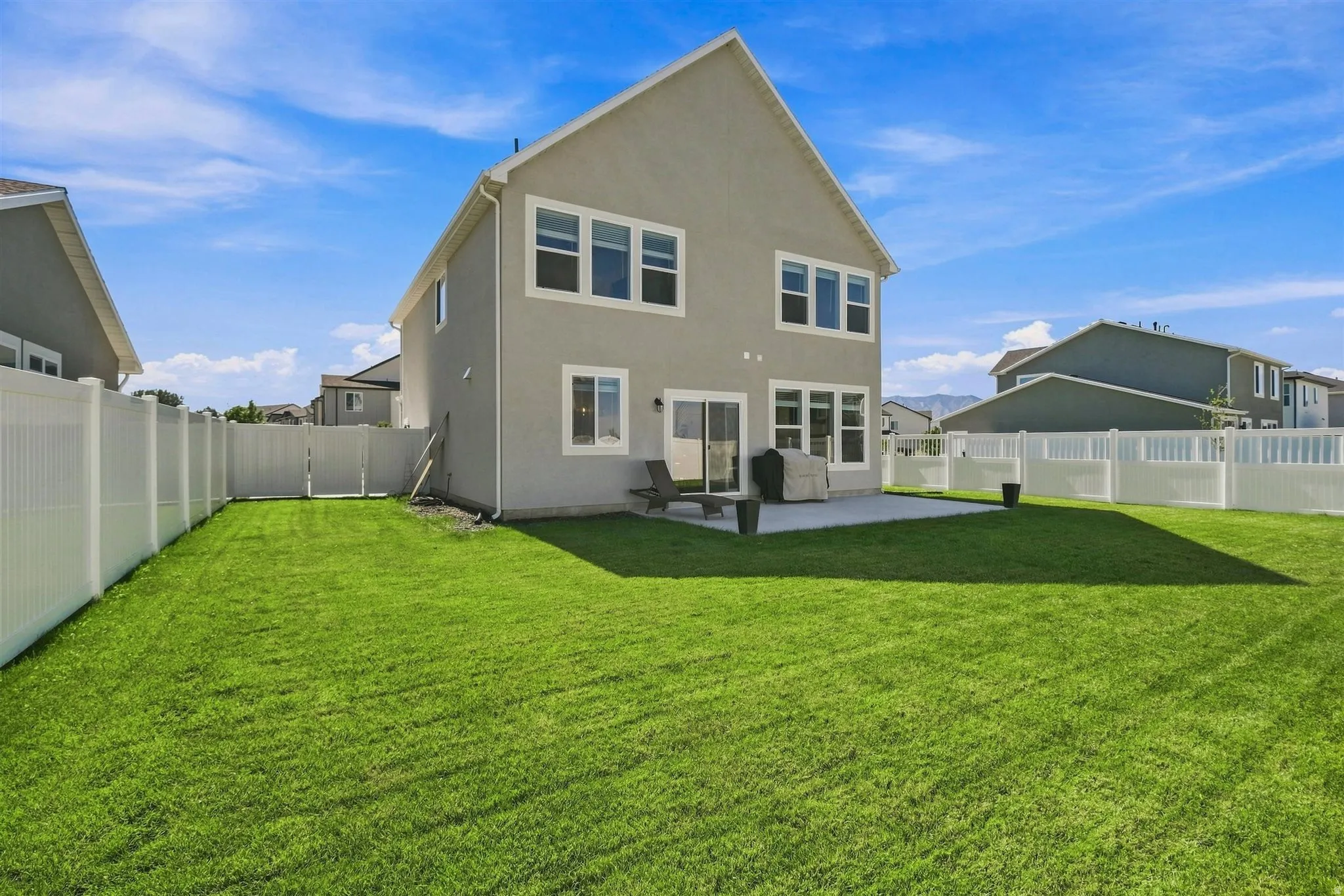 Expansive backyard featuring a manicured lawn, a concrete patio, and a privacy fence
