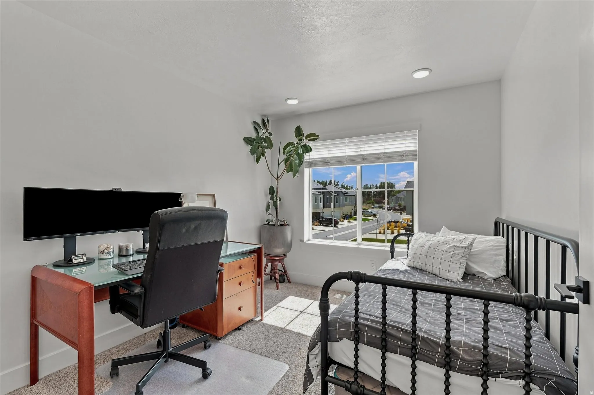 Recessed lighting, light-colored walls, carpeted flooring, and a window with blinds