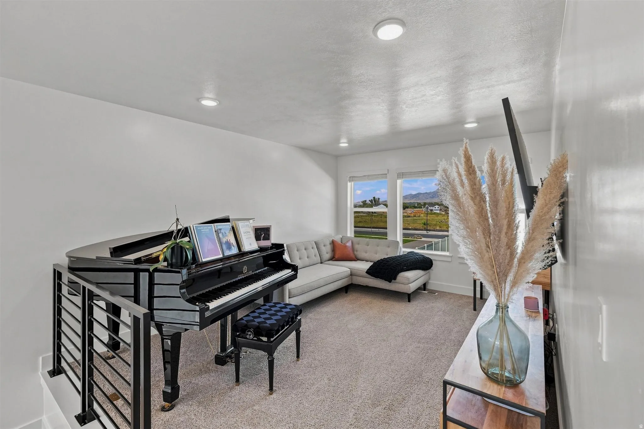 Recessed lighting, large windows, wall-to-wall carpeting, and metal railing