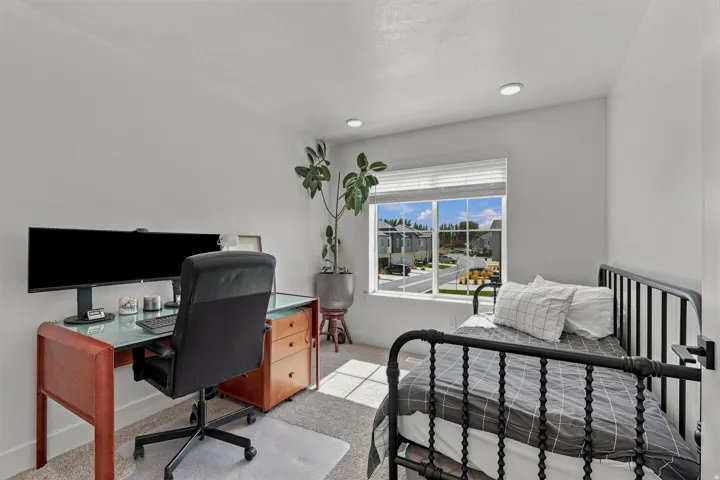 Recessed lighting, light-colored walls, carpeted flooring, and a window with blinds