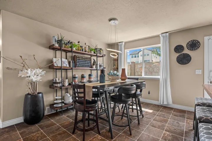 Tiled flooring, built-in shelving, suspended lighting fixture, and a large window