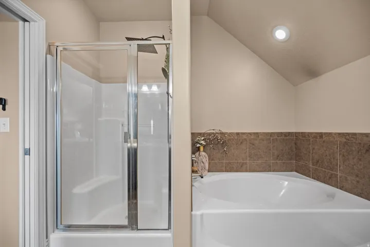 Built-in shower with clear glass enclosure, overhead rainfall showerhead, and recessed lighting