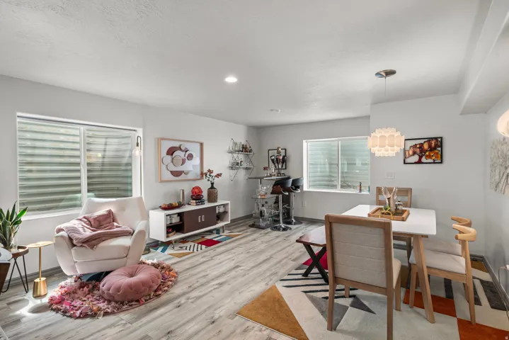 Recessed ceiling lighting, wood-finish flooring, white walls, and a contemporary pendant light fixture