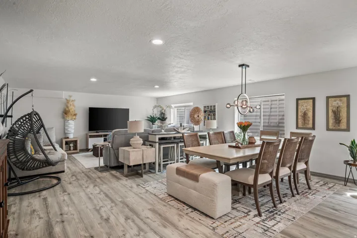 Open-concept common area featuring wood-finish flooring, recessed lighting, and a contemporary chandelier