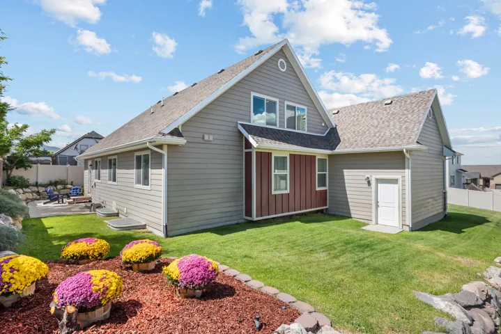 Multi-level exterior with siding, a concrete patio, and a sloped lawn