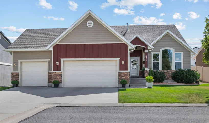 Exterior featuring a two-car garage, stone accents, gabled rooflines, and a covered entry
