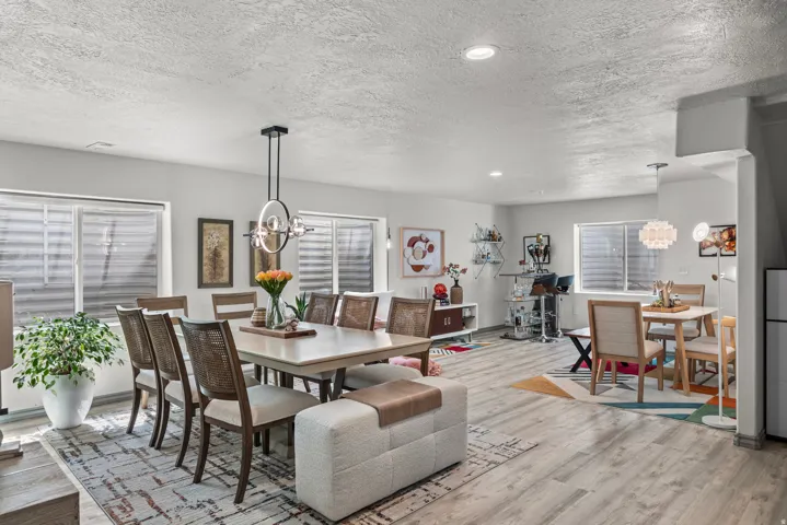 Open-concept living space featuring wood-finish flooring, recessed lighting, and multiple windows