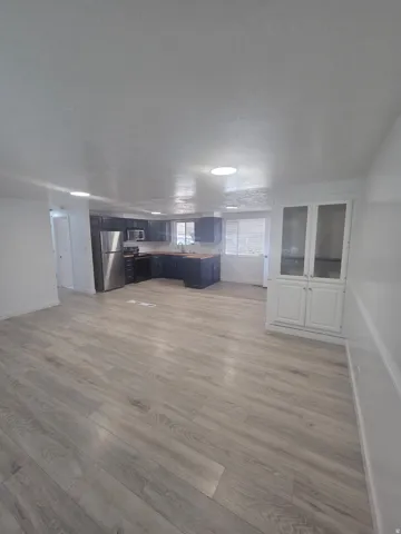 Open-concept living space with wood-finish flooring, recessed lighting, and built-in cabinetry